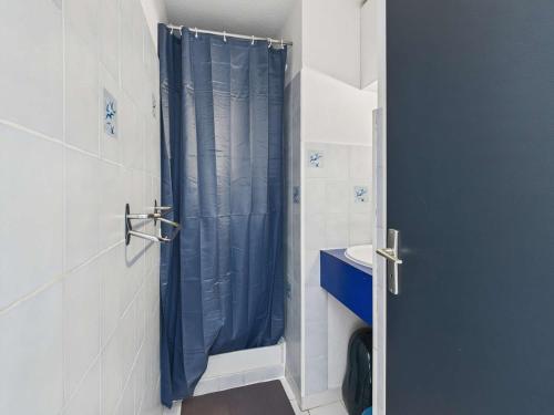 une salle de bain avec une douche avec un rideau de douche bleu dans l'établissement Appartement cosy 2 pièces, 4 pers., à 2 pas de la plage, parking privé, terrasse avec salon de jardin - FR-1-326-815, à Marseillan
