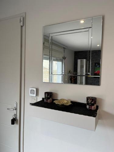 - un miroir sur un mur au-dessus d'une étagère dans la salle de bains dans l'établissement Villa privative 3 chambres et piscine priv près Carcassonne, à Carcassonne