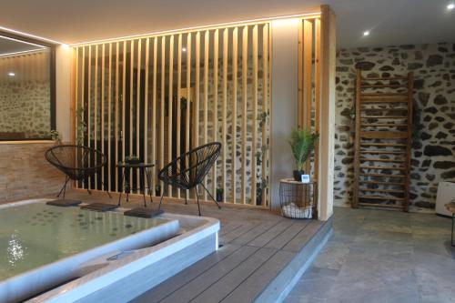 une chambre avec un jacuzzi et une terrasse en bois dans l'établissement Domaine Le Vernet, à Dore-lʼÉglise