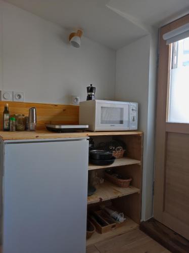 une cuisine avec un four micro-ondes au-dessus d'un comptoir dans l'établissement Studio Rezé, à La Celle-sous-Gouzon