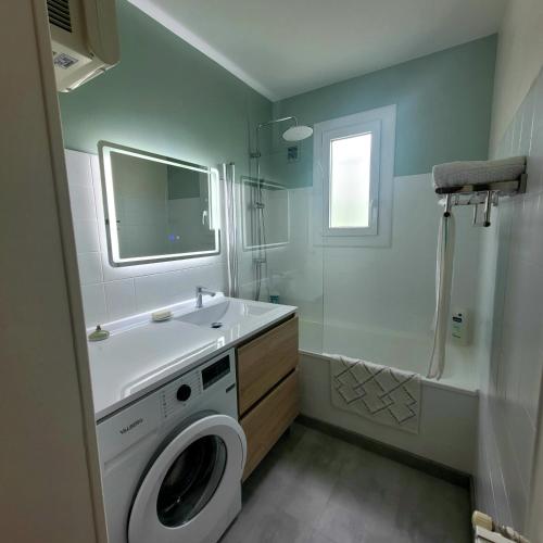 une salle de bain avec une machine à laver et un lavabo dans l'établissement La Maison, à Le Mas-dʼAzil