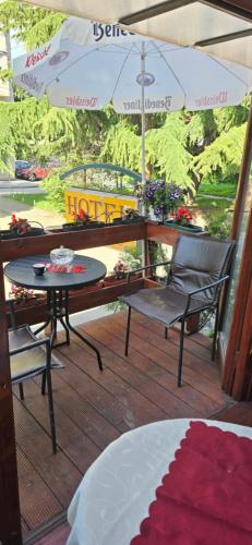 a patio with a table and chairs and an umbrella at Hotel Kapistec Skopje in Skopje