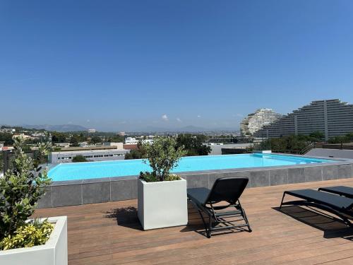 un balcon avec deux chaises et une piscine dans l'établissement Rooftop Pool, à Villeneuve-Loubet
