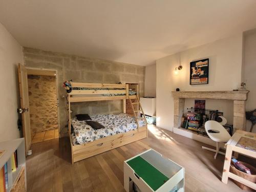 - une chambre avec des lits superposés et une cheminée dans l'établissement Charmante maison de village, à Boulbon