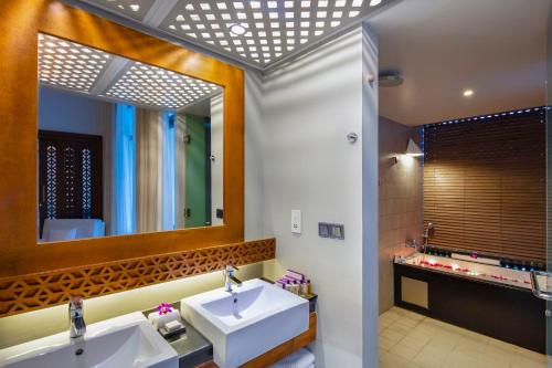 a bathroom with two sinks and a large mirror at Cinnamon Bey Beruwala in Bentota