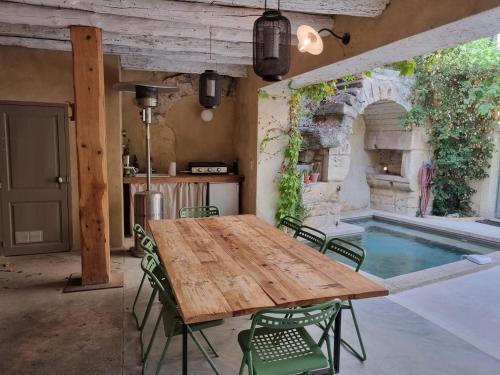 une salle à manger avec une table et une piscine dans l'établissement Charmante maison de village, à Boulbon