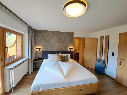 a bedroom with a large white bed with a window at Der Trueferhof in Ehrwald