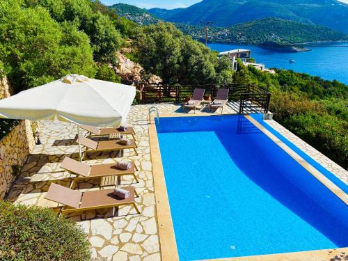 a swimming pool with chairs and an umbrella next to the water at The Lookout, boutique villa. in Sivota