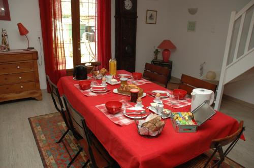 a table with a red table cloth with food on it at La Palombiere in Lucmau