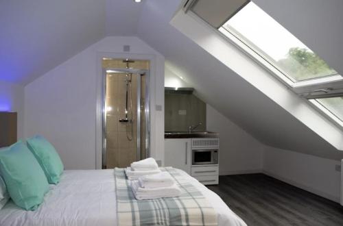 a white bedroom with a bed and a bathroom at Crosskeys Edinburgh in Edinburgh