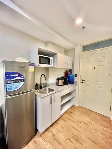 a kitchen with a stainless steel refrigerator and a sink at Amani Luxe Free Pool and Gym access in Lapu Lapu City