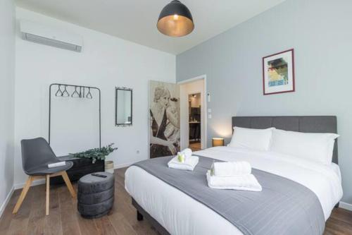 une chambre avec un grand lit et une chaise dans l'établissement 5 min walk to Sea & Tram, à Nice
