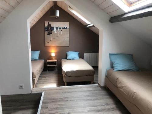 une chambre mansardée avec deux lits et une fenêtre dans l'établissement Villa des 4 saisons, à Cucq