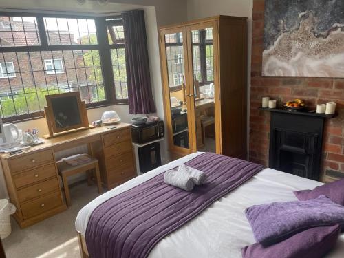 a bedroom with a bed and a desk and a television at Camaraderie Guest House in York