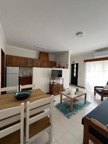a living room with a table and a kitchen at Encosta do Sol in Canas de Senhorim