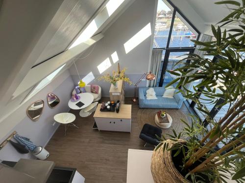 sala de estar con sofá azul y algunas plantas en Appartement Oan it Pikmar, en Grou