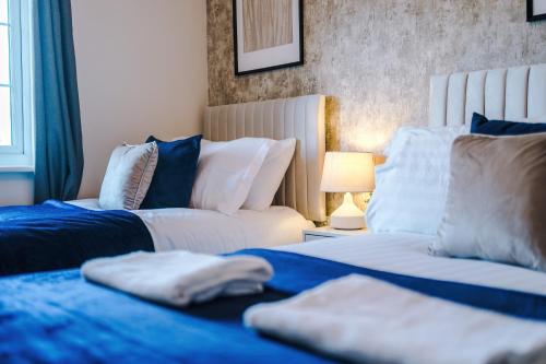 a bedroom with two beds and a couch at 3 Bedrooms Driveway Walk 2 JLR Halewood Airport - 5 Beds- 3 WC-Speke Boulevard-South Liverpool-Sleeps 9 - Fully Equipped- Docks- Waterfront Bank Arena Liverpool by Arz Stays in Liverpool