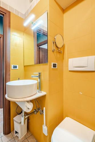 a yellow bathroom with a sink and a toilet at Oasi di Mare next Rome Airport in Fregene