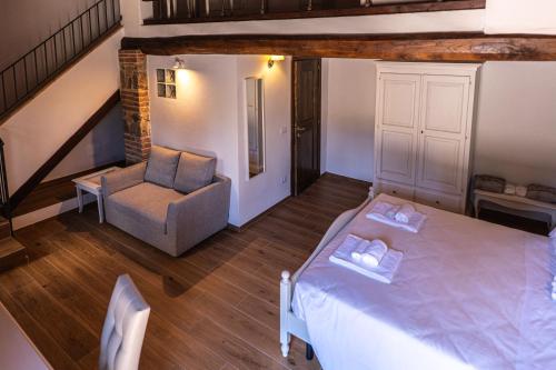 a bedroom with a bed and a chair and a staircase at Borgo Il Poggiaccio Residenza d'Epoca in Sovicille