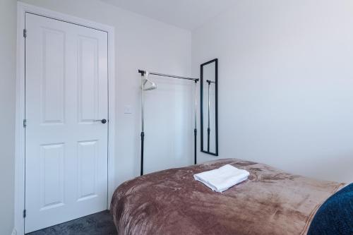 a white bedroom with a bed and a closet at 3 Bedrooms Driveway Walk 2 JLR Halewood Airport - 5 Beds- 3 WC-Speke Boulevard-South Liverpool-Sleeps 9 - Fully Equipped- Docks- Waterfront Bank Arena Liverpool by Arz Stays in Liverpool