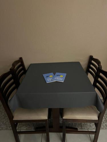 a black table with two chairs and a book on it at Chalé em Parque Aquático - Presidente Figueiredo in Presidente Figueiredo