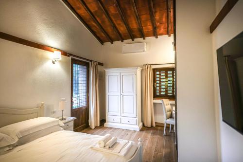 a bedroom with a bed and a table and a chair at Borgo Il Poggiaccio Residenza d'Epoca in Sovicille