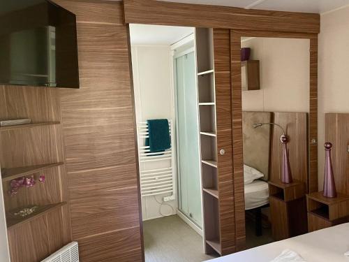 - une chambre avec un grand miroir dans l'établissement Pleasant Mobile Home Ba680 - Siblu Bonne Anse La Palmyre, aux Mathes