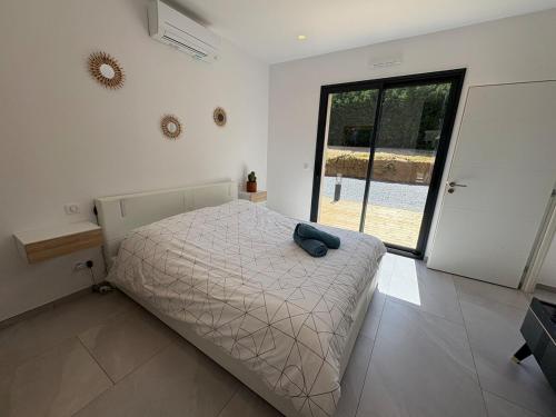 une chambre avec un lit et une grande fenêtre dans l'établissement Ramatuelle - Proche plage Escalet - Maison 6 Pers - Jardin - Terrasse - Parking 3 voitures, à Ramatuelle