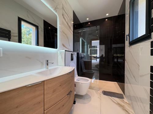 une salle de bain avec toilettes, lavabo et miroir dans l'établissement Ramatuelle - Proche plage Escalet - Maison 6 Pers - Jardin - Terrasse - Parking 3 voitures, à Ramatuelle