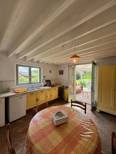 - une grande cuisine avec une table dans une chambre dans l'établissement Maison de Tout Vent, à Pierrefonds