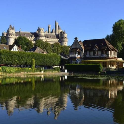 le reflet d'un bâtiment dans l'eau avec une maison dans l'établissement Maison de Tout Vent, à Pierrefonds