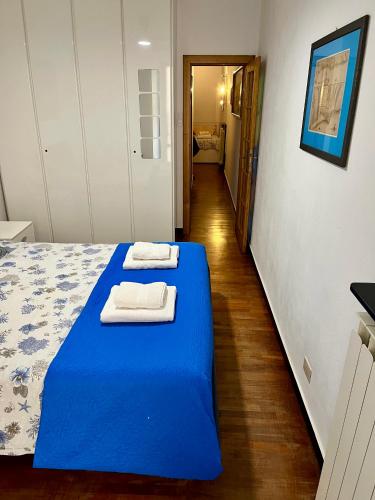 a bedroom with a blue bed with towels on it at Casa Alba in Monterosso al Mare