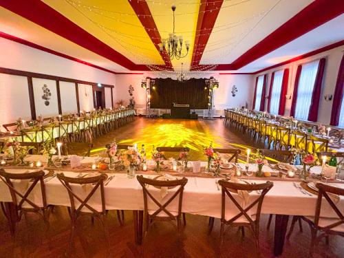 a banquet hall with tables and chairs and a dance floor at Hotel Ruhekrug in Schleswig