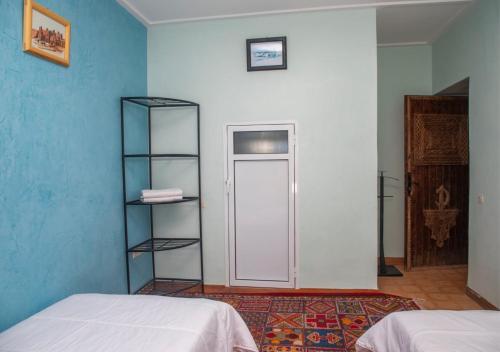 a room with two beds and a white door at Bassatine Skoura in Skoura