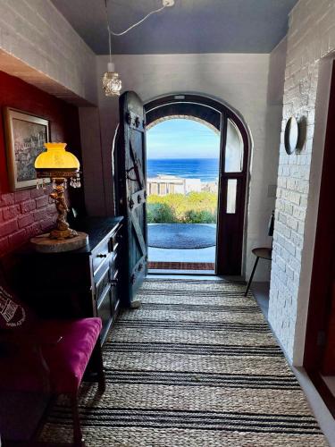 a hallway with an open door with a view of the ocean at Yzerfontein 3 Bed House with Pool & Sea Views in Yzerfontein