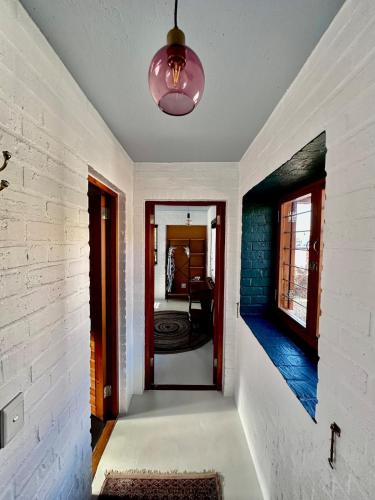 a hallway with a brick wall and a pendant light at Yzerfontein 3 Bed House with Pool & Sea Views in Yzerfontein