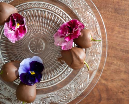 three flowers on a glass plate on a wooden table at Enchanted Manor in Niton