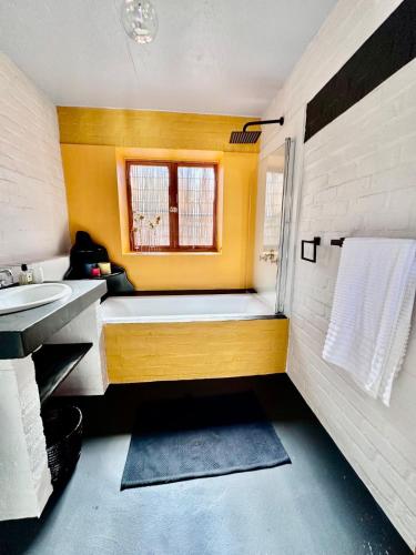 a bathroom with a bath tub and a sink at Yzerfontein 3 Bed House with Pool & Sea Views in Yzerfontein