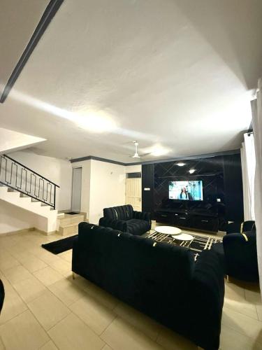a living room with a couch and a flat screen tv at Greenwood Garden 3Bedroom Mtwapa in Mtwapa