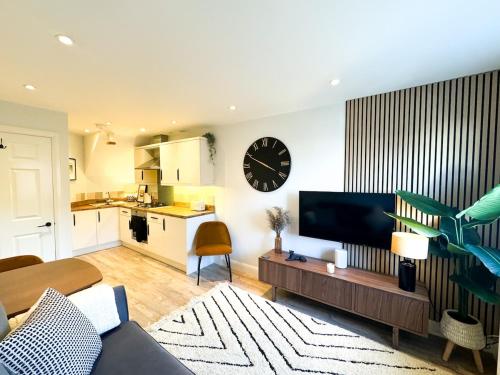 a living room with a large clock on the wall at Stylish apartment 1 min to town centre and harbour in Lymington