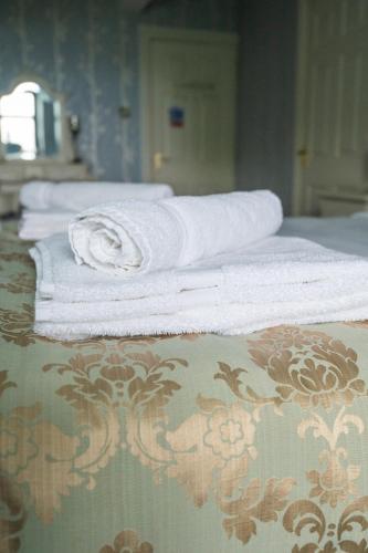 a group of towels sitting on top of a bed at Enchanted Manor in Niton