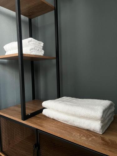 une étagère avec des serviettes blanches au-dessus dans l'établissement Maison de ville, à Vichy