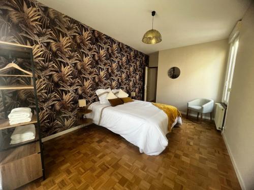 ヴィシーにあるMaison de villeのベッドと壁画が備わるホテルルーム