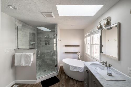 Un baño con bañera, lavabo y ducha. en Luxurious Downtown Location - Entire house, en Indianápolis