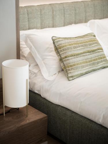 a bed with a pillow and a lamp on a table at Agriturismo Prà dell'Ort - Wishing Wellness in Valdobbiadene