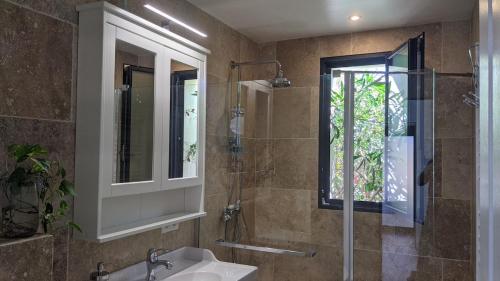 une salle de bain avec un lavabo, une douche et un miroir dans l'établissement Family home with garden, pool and beach within walking distance, à Lacanau