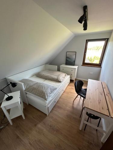 a bedroom with a bed and a wooden table at Przystanek Zawóz in Zawóz