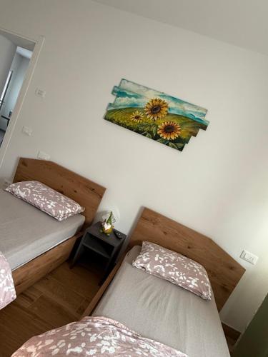 a room with two beds and a painting on the wall at Appartamenti Ai 7 nani in Peron