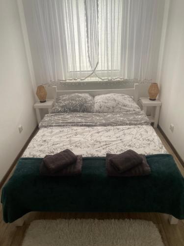 a bedroom with a bed with two pillows on it at APARTAMENT MARTA in Zamość
