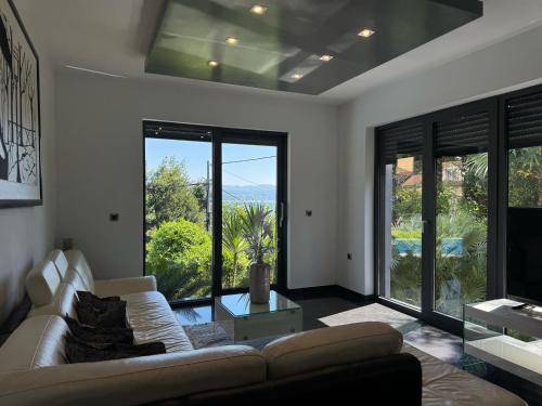 a living room with a couch and a large window at Apartment Villa Marjanovic in Opatija